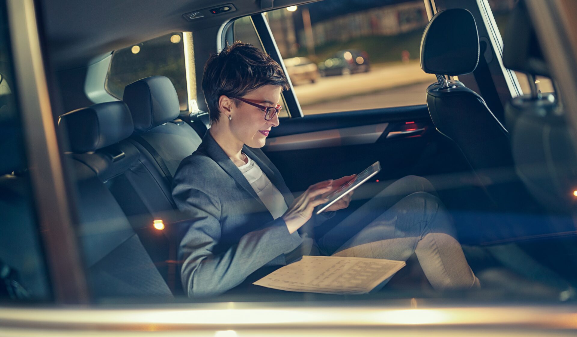 Zakelijke professional werkt onderweg op een tablet in de auto